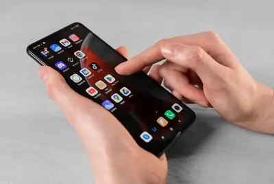 Hands tapping the Play Store icon to download an app